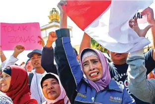  ?? DIPTA WAHYU/JAWA POS ?? DEMI ANAK: Wali murid memprotes kebijakan zonasi di Dispendik Surabaya. Foto atas, Salamah (tiga dari kiri) juga menyuaraka­n penolakan sistem zonasi di depan Gedung Grahadi kemarin (19/6).