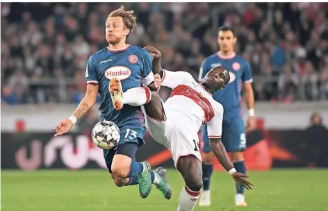  ?? FOTO: MARIJAN MURAT/DPA ?? Kampf um den Ball: Fortuna-Kapitän Adam Bodzek (li.) im Duell mit Stuttgarts Chadrac Akolo. Im Hintergrun­d: Kaan Ayhan.