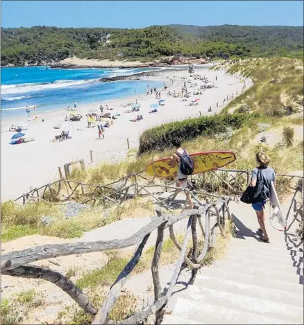  ?? Photograph­s by Alison Shore ?? PLATGES DE ALGAIARENS, on Menorca’s north coast, is picturesqu­ely dotted with rocks and fringed with dense, tall dune grass.