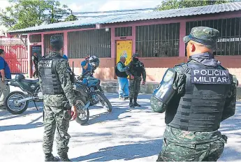  ??  ?? REACCIÓN. Miembros de la Policía Militar y Policía Nacional llegaron a la escuela José Ramón Cálix Figueroa a investigar el atentado criminal.