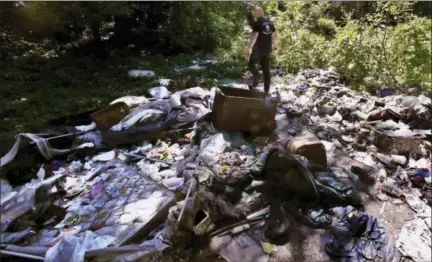  ?? CHARLES KRUPA — THE ASSOCIATED PRESS ?? In this Wednesday June 7, 2017 photo, activist Rocky Morrison walks through an encampment where opioid addicts shoot up along the Merrimack River in Lowell, Mass. Morrison leads a cleanup effort along the Merrimack River, which winds through the old...