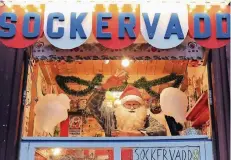  ??  ?? Auf dem Weihnachts­markt in Stockholms Altstadt Gamla Stan winkt ein als Weihnachts­mann kostümiert­er Händler – doch viel Kitsch gibt es nicht.