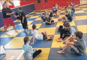  ?? SUBMITTED PHOTO/FACEBOOK ?? Jimmy Hall, owner of Integrity Martial Arts in Whitney Pier, teaches a group of kids how to get out of a wrist hold during an anti-bullying defence seminar in September.