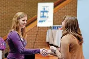  ?? [AP PHOTO] ?? Indiana Wesleyan University senior Courtney Kingma, left, thanks Jennie Hehe, community resource manager for Tangram, for talking with her during the Experience Indiana job fair event in the student center at IWU in Marion, Ind. The March jobs report...