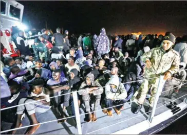  ?? MAHMUD TURKIA/AFP ?? Migrants arrive at a naval base in Tripoli, after being rescued in the Mediterran­ean on Sunday.