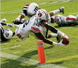  ?? BOB LEVEY / GETTY IMAGES ?? Receiver Eli Stove, diving for a touchdown in the win over Texas A&M, is among a variety of weapons in a balanced attack in Auburn’s improving offense.