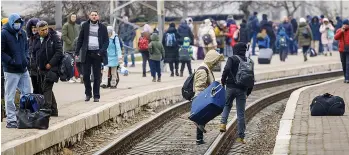  ?? ?? Exodus...refugees at Lyviv railway station hoping to flee the war that has engulfed Ukraine