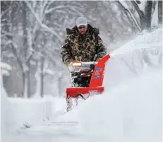  ??  ?? SIOUX FALLS, South Dakota: A man uses a snow blower to clear the sidewalk near his house during the first snow of the season on Friday. — AP