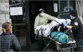  ?? JOHN MINCHILLO — THE ASSOCIATED PRESS FILE ?? On April 17, a patient is wheeled into Cobble Hill Health Center by emergency medical workers in the Brooklyn borough of New York.