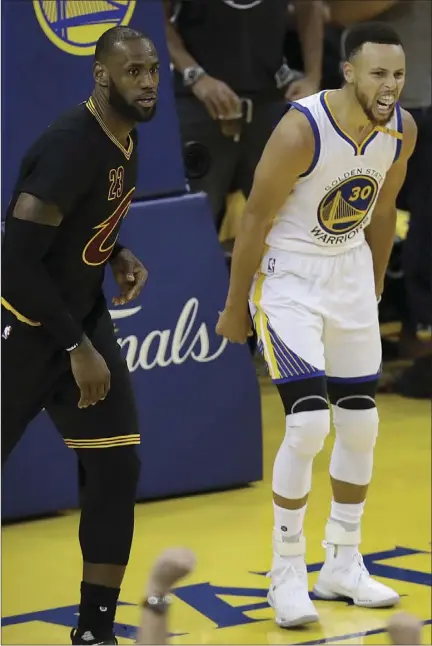  ?? AP PHOTO ?? Golden State Warriors guard Stephen Curry (right) reacts after scoring next to Cleveland Cavaliers forward LeBron James during the second half of Game 2 of basketball's NBA Finals on Sunday in Oakland.