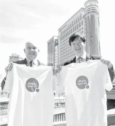  ??  ?? Ong (right) and OCBC Al-Amin chief executive officer Tuan Syed Abdull Aziz Syed Kechik are seen in front of Menara OCBC with the Simply Spot On T-shirts that OCBC staff nationwide will wear on designated days in conjunctio­n with the rollout of the Brand Promise.