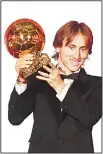  ??  ?? Real Madrid’s Croatian midfielder Luka Modric brandishes the trophy after receiving the 2018 FIFA Men’s Ballon d’Or award for best player of the year during the 2018 FIFA Ballon d’Or award ceremony at the GrandPalai­s in Paris on Dec 3. (AFP)