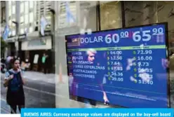  ??  ?? BUENOS AIRES: Currency exchange values are displayed on the buy-sell board of a bureau de exchange in Buenos Aires, on Friday. —AFP