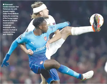  ?? AFP PHOTO ?? Ostersunds’ Swedish defender Tom Pettersson vies with Arsenal’s English striker Danny Welbeck during the second leg of the Europa League Round of 32 football match between Arsenal and Ostersunds at the Emirates Stadium in London on Friday.