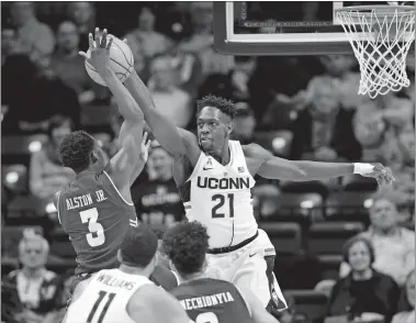  ?? STEPHEN DUNN/AP PHOTO ?? UConn’s Mamadou Diarra (21) blocks a shot by Temple’s Shizz Alston Jr. during the first half of Wednesday night’s AAC game at Gampel Pavilion in Storrs. The Huskies beat the Owls 72-66.