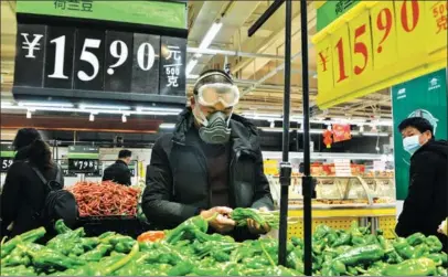  ?? HU XUEJUN / FOR CHINA DAILY ?? Customers buy vegetables at a supermarke­t in Yunmeng county, Xiaogan, Hubei province, on Jan 29.