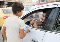  ?? AFP ?? An Iraqi child pedlar sells tissue paper to moving cars in the northern Iraqi city of Mosul. —