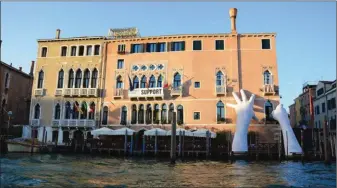  ??  ?? La sculpture de l’artiste Lorenzo Quinn représenta­nt deux mains soutenant Venise et symbolisan­t la force créatrice et destructri­ce de l’homme a pour but de sensibilis­er aux risques du réchauffem­ent climatique.