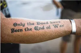  ?? MAX WHITTAKER / THE NEW YORK TIMES ?? Logan Hastings displays a tattoo during a 1,750-mile kayak trip he and his father, also a veteran, made in 2017. Many veterans turn to trekking to find serenity in a life upended by combat. “I’ve lost more friends here than I ever lost overseas,” Logan said. “It takes a long time to get over everything that’s happened.”