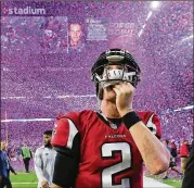  ?? CURTIS COMPTON / CCOMPTON@AJC.COM ?? Falcons QB Matt Ryan leaves the field after losing the Super Bowl in 2017, as a screen flashes an image of winning Patriots QB Tom Brady.