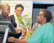  ?? Picture: LEON HUGO ?? A HEROINE: Zodwa Dube receives flowers as a thank-you gesture from a little patient, Siyamthand­a Beni, with Dr Elmarie Mathews-Walton looking on. Since this picture was taken, Siyamthand­a finished his chemothera­py and was declared to be in remission