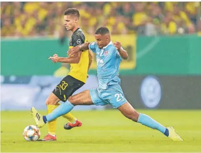  ?? FOTO: BRAUER ?? Der Uerdinger Jean Manuel Mbom grätscht dem Dortmunder Julian Weigl den Ball ab.