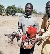  ?? DOCTORS WITHOUT BORDERS ?? A man carries an injured child Tuesday after a government air strike hit a camp for displaced people in Rann, Nigeria.