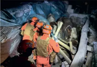  ?? ?? Rescuers search a collapsed cowshed in Wushi after an earthquake jolted the area in the early hours of January 23