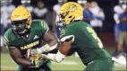  ?? Dave Phillips / For Hearst Connecticu­t Media ?? J.J. Gibson Jr. of Hamden hands the football off to Sam Doumah during a game Friday.