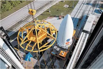  ?? KIM SHIFLETT/NASA ?? A crane will hoist the payload nose cone containing the Perseveran­ce rover onto the Atlas V launch vehicle in Florida.