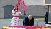  ?? AP ?? Donald Trump and first lady Melania Trump offer floral respects at Raj Ghat, the memorial for Mahatma Gandhi, in New Delhi on Tuesday. —