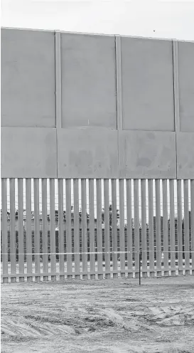  ?? Associated Press file ?? A border wall prototype stands near the border with Tijuana, Mexico, last month. Bidders on the border wall project, worried about a financial backlash from state and local government­s, have asked the White House for help.