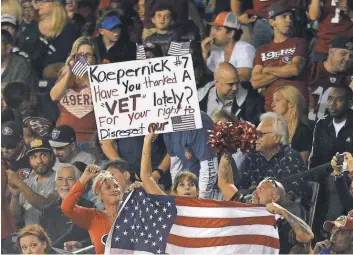  ?? JAKE ROTH, USA TODAY SPORTS ?? Fans hold a sign and U. S. flag in response to Colin Kaepernick’s national anthem protest during a 49ers- Chargers preseason game Sept. 1 in San Diego.