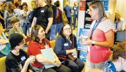  ?? STAFF PHOTO BY C.B. SCHMELTER ?? Noah Riley, left, and his mother Stacey Kight, second from left, listen as Staci Smith talks to them during the Pectacular! ice cream social in the University Surgical Associates office in Erlanger Health System’s Medical Mall in April. Smith’s daughter had the surgery.