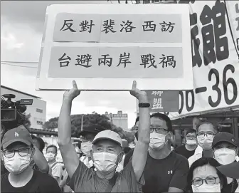  ?? SAM YEH / AFP ?? A Taiwan resident displays a placard reading “oppose Pelosi visit to avoid war between two shores” as US House Speaker Nancy Pelosi arrived in New Taipei City on Wednesday.