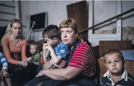  ?? DIMITAR DILKOFF/ AFP/GETTY IMAGES ?? Adults and children take refuge in a bomb shelter in an orphanage during a shelling attack in the town of Makiyivka, Ukraine, on Monday.