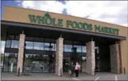  ?? AP PHOTO ?? In this May 3, 2017, photo, people stand outside a Whole Foods Market in Upper Saint Clair, Pa. Amazon’s planned $13.7billion acquisitio­n of Whole Foods signals a massive bet that people will opt more for the convenienc­e of online orders and delivery...