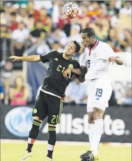  ?? Mel Evans Associated Press ?? MEXICO’S Carlos Esquivel, left, and Costa Rica’s Roy Miller ( 19) duel for the ball during overtime in a CONCACAF Gold Cup quarterfin­al. Mexico won, 1- 0.