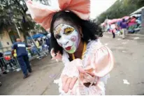  ?? Associated Press ?? A member of the New Orleans Baby Doll Ladies walks down St. Charles Avenue on Tuesday ahead of the Zulu Parade during Mardi Gras in New Orleans.