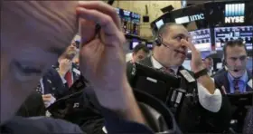  ?? RICHARD DREW — THE ASSOCIATED PRESS ?? In this Nov. 9 photo, Anthony Riccio, center, works with fellow traders on the floor of the New York Stock Exchange. Investors have been yanking money out of bonds around the world, sending prices tumbling and wiping out several months of gains in...
