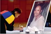  ?? PICTURE: THOBILE MATHONSI ?? Dudu Mdaka lights candles next to a portrait of TV and radio personalit­y Hope Zinde at the Methodist Church in Mamelodi.