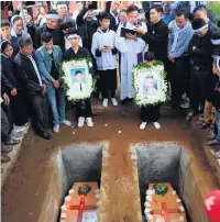  ??  ?? Family members of Hoang Van Tiep pray over his coffin at the cemetery; a grief-stricken woman at the funeral; the remains of Nguyen Van Hung (left) and Hoang Van Tiep are laid to rest. Below, family members at the funeral