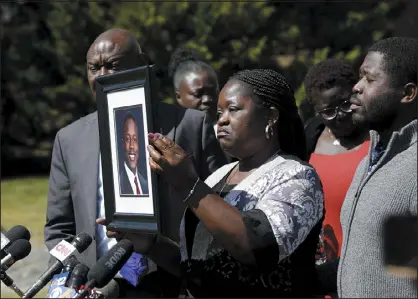  ?? DANIEL SANGJIB MIN — RICHMOND TIMES-DISPATCH VIA AP ?? Caroline Ouko, mother of Irvo Otieno, holds a portrait of her son with attorney Ben Crump, left, and her older son, Leon Ochieng, at the Dinwiddie Courthouse in Dinwiddie, Va., on Thursday. She said Otieno, who died in a state mental hospital March 6, was “brilliant and creative and bright.”