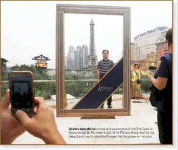  ?? BOBBY YIP / REUTERS ?? Visitors take photos in front of a scale replica of the Eiffel Tower in Macao on Aug 16. The tower is part of the Parisian Macao built by Las Vegas Sands, and is scheduled to open Tuesday.