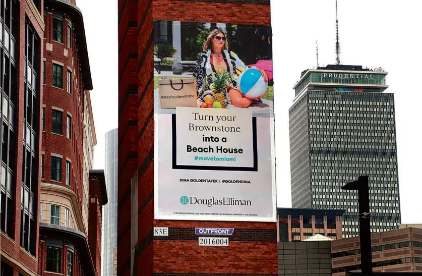  ?? JOHN TLUMACKI/GLOBE STAFF ?? A Move to Miami billboard hangs near the Copley Square T station facing Columbus Avenue.