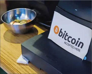  ?? LEON NEAL / AFP ?? A coffee shop sign advertises that the digital currency bitcoin is accepted, in central Dublin, earlier this year.