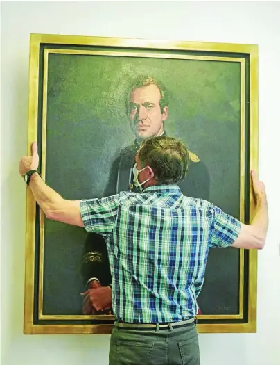  ?? EP ?? Un operario retira el retrato de Don Juan Carlos de la sede del Parlamento de Navarra en junio de 2020