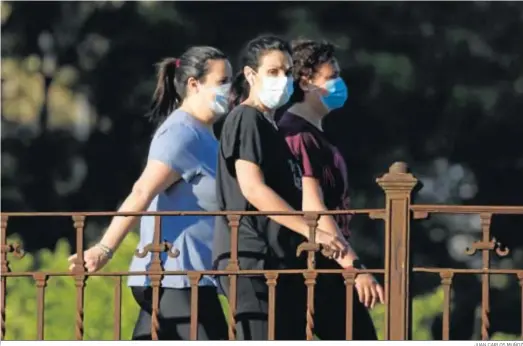  ?? JUAN CARLOS MUÑOZ ?? Tres mujeres dan un paseo ayer protegidas por las mascarilla­s en Sevilla.