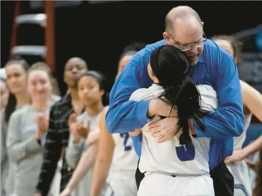  ?? MORRY GASH/AP PHOTOS ?? Christophe­r Newport women’s basketball coach Bill Broderick hugs Gabbi San Diego late in the Captains’ 57-52 loss to Transylvan­ia in the NCAA Division III championsh­ip game Saturday at American Airlines Arena in Dallas.