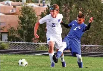  ?? GABRIELA CAMPOS/THE NEW MEXICAN ?? St. Michael’s senior Sam Baca, center, dribbles past Questa’s Miguel Romero on Tuesday during a 6-0 win for the Horsemen at Christian Brothers Athletic Complex.